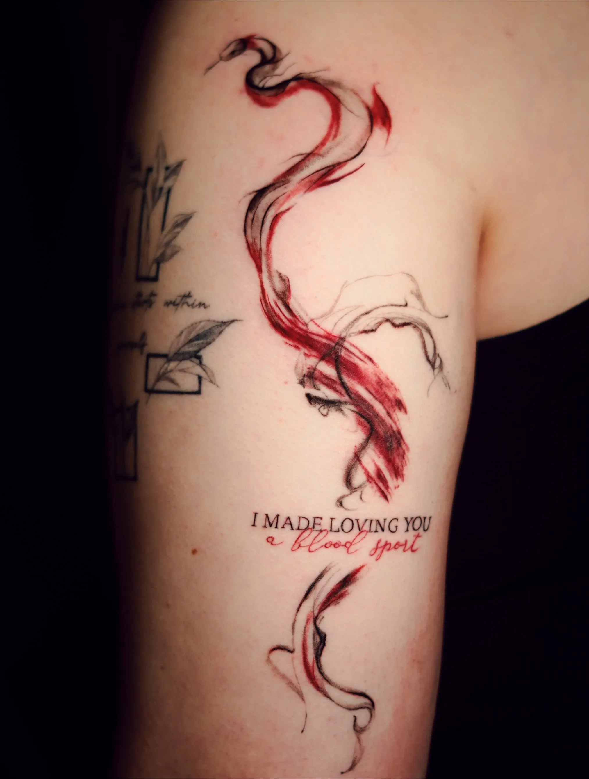 Abstract tattoo with red and typography that reads i made loving you a blood sport