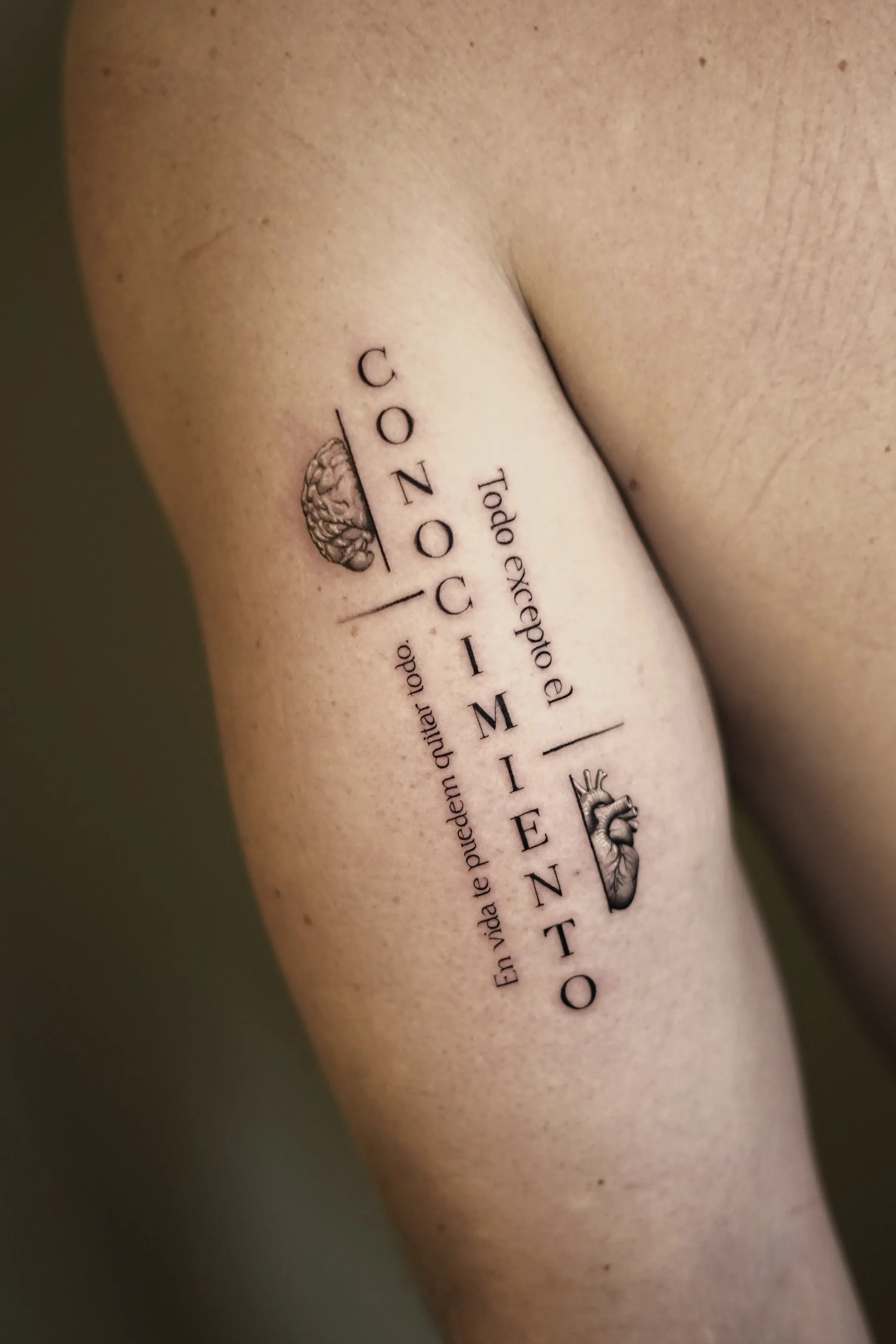 Fine line typography tattoo that says conocimiento