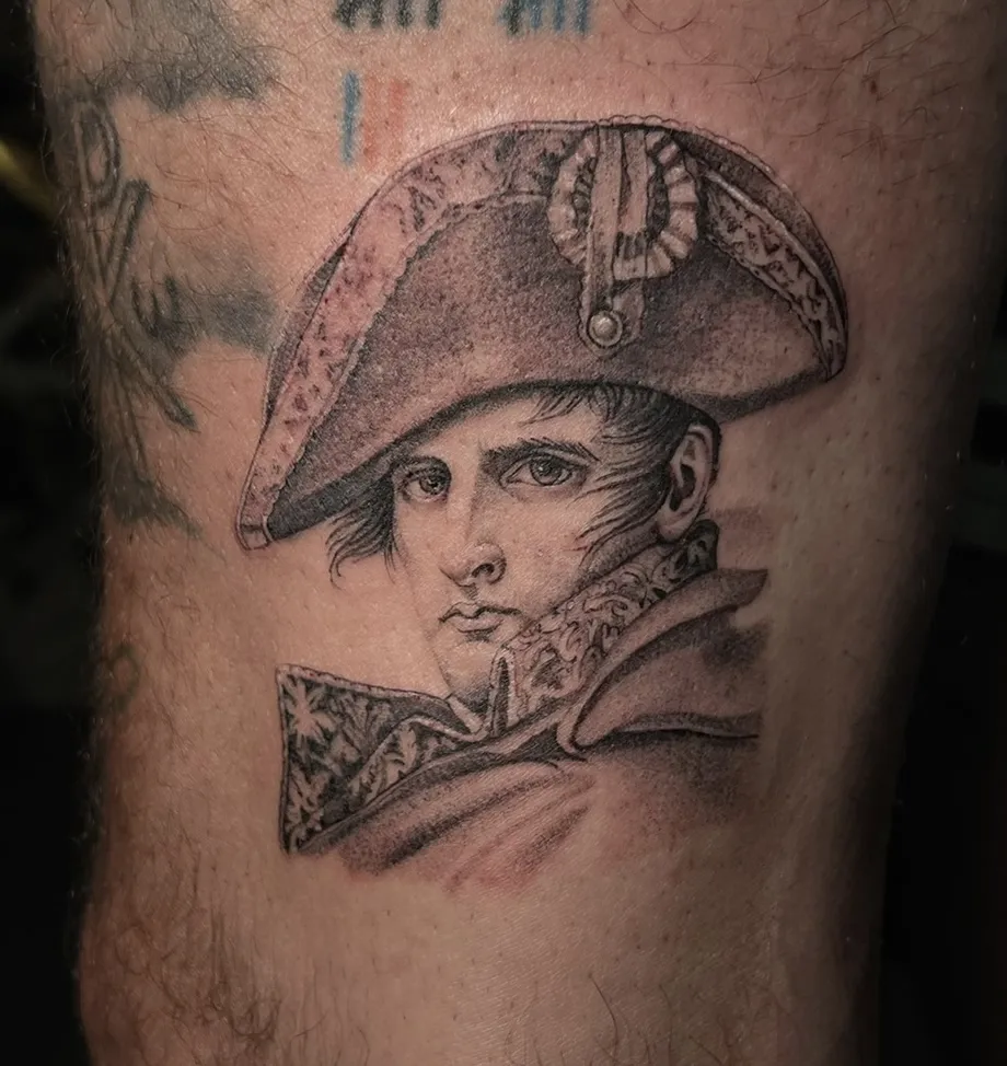 Microrealism captain portrait tattoo featuring realistic facial details and fine black and grey shading.